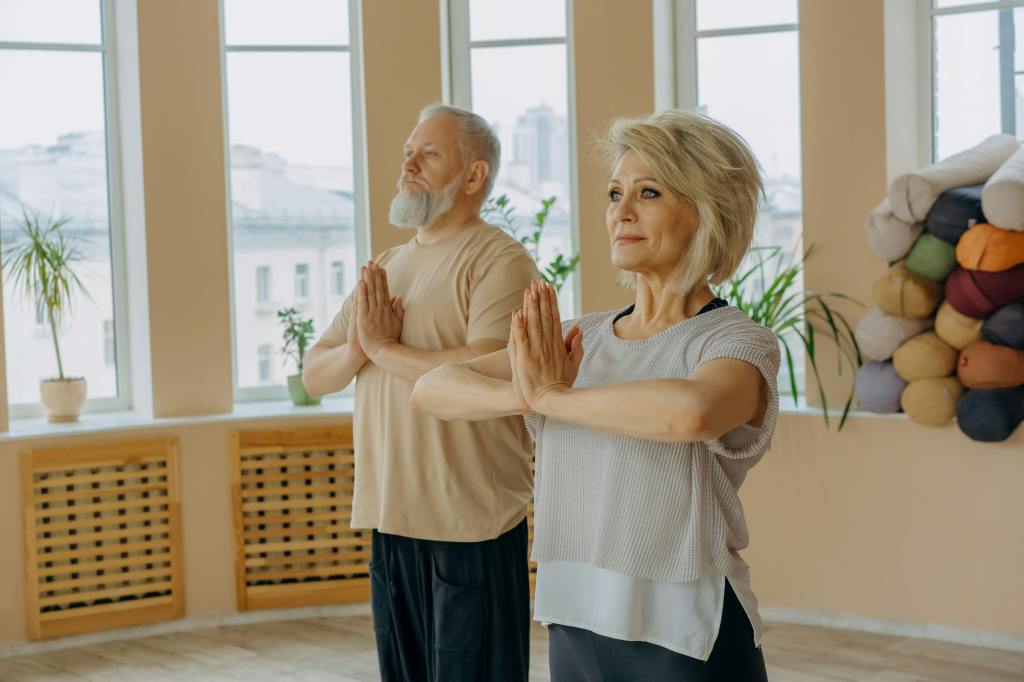 Elderly man and woman doing yoga balance exercise mountain pose