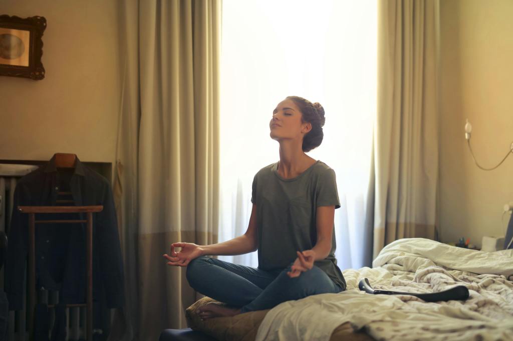 girl meditating in her room calmly in sunlight