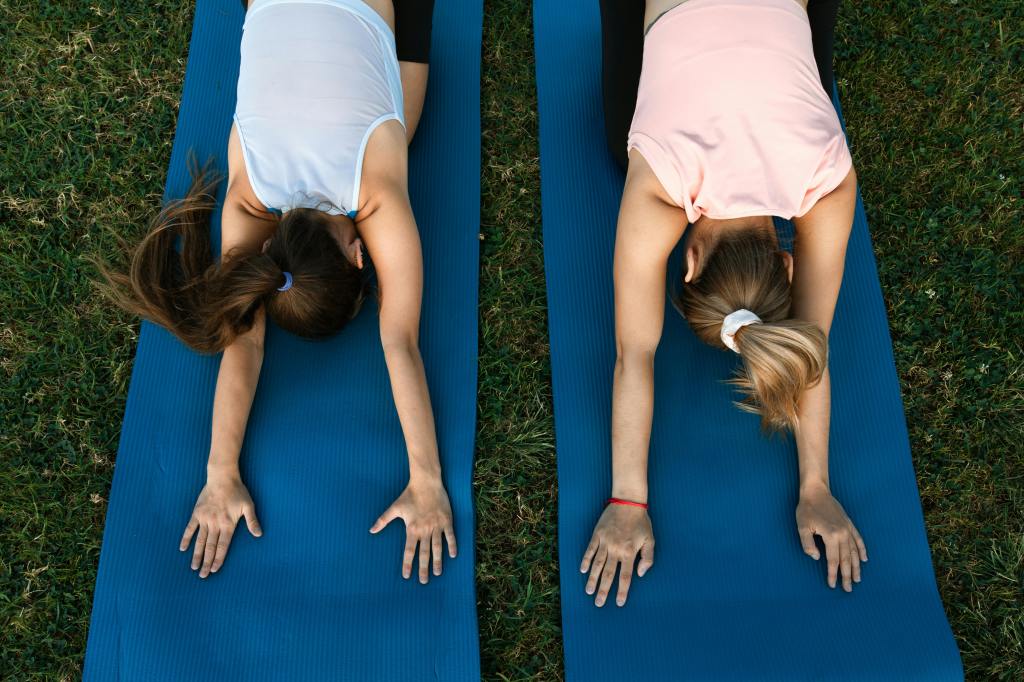 People doing the childs pose on a yoga mat