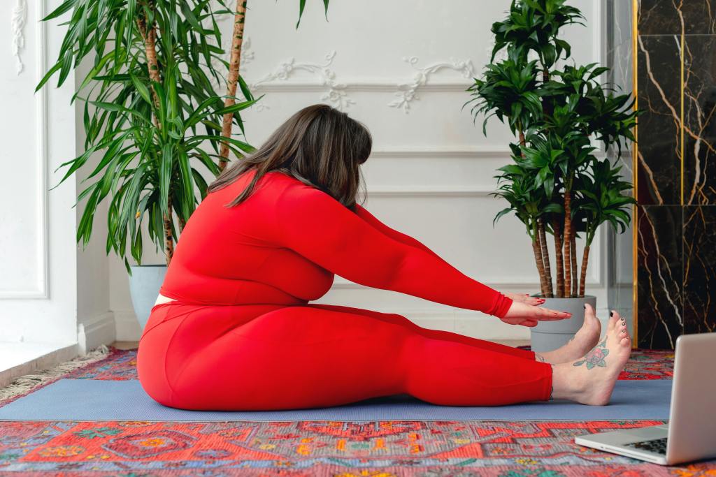 Overweight woman doing seated forward hold yoga pose for stretching