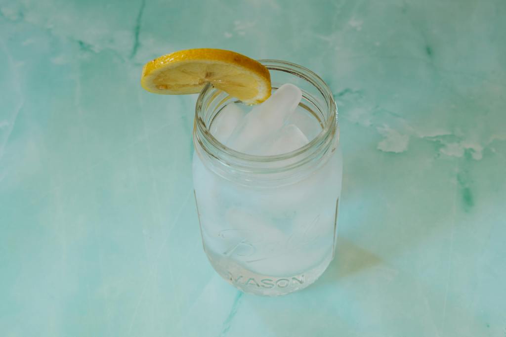 A glass of lemon water with ice inside.