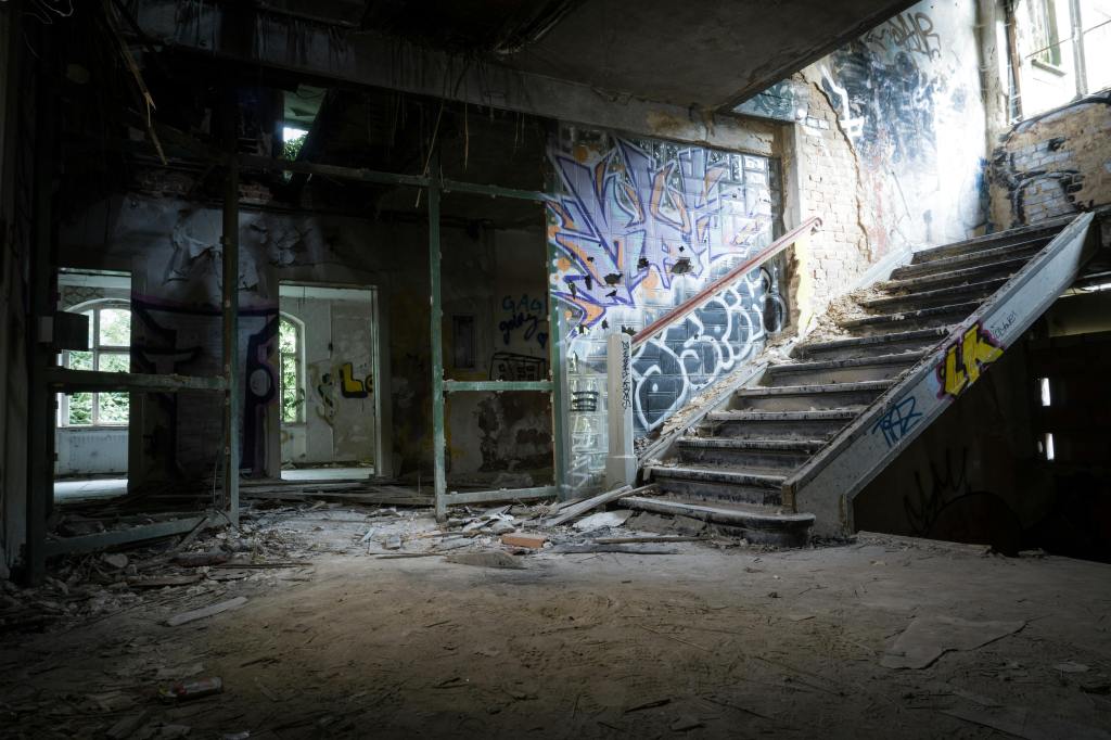 An abandoned building with graffiti and hidden spots.