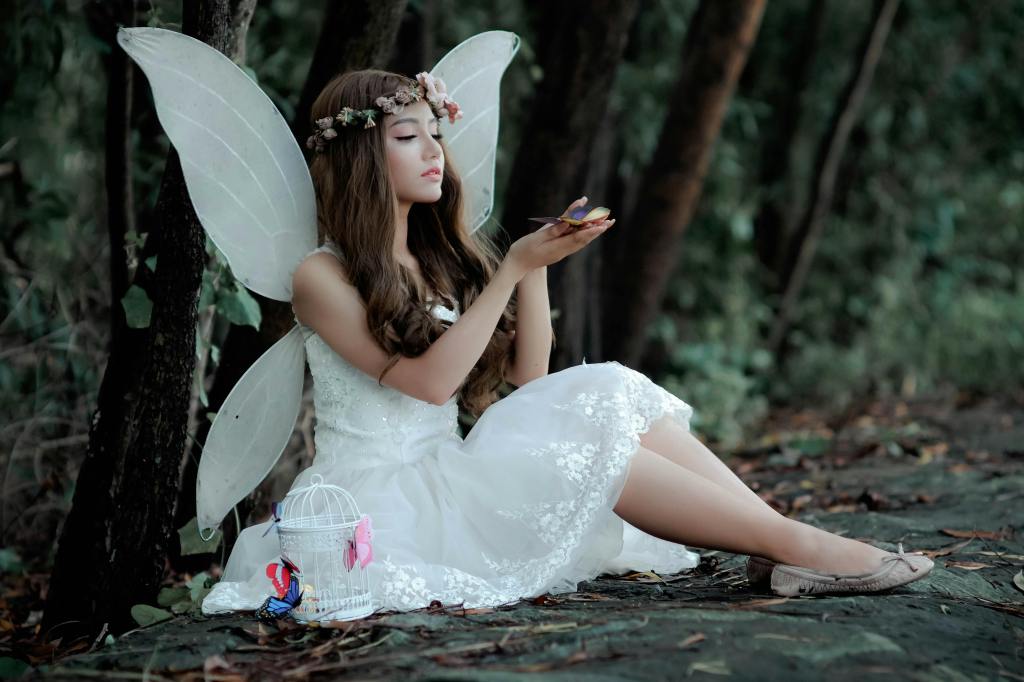 A young girl dressing up as a fairy in nature.